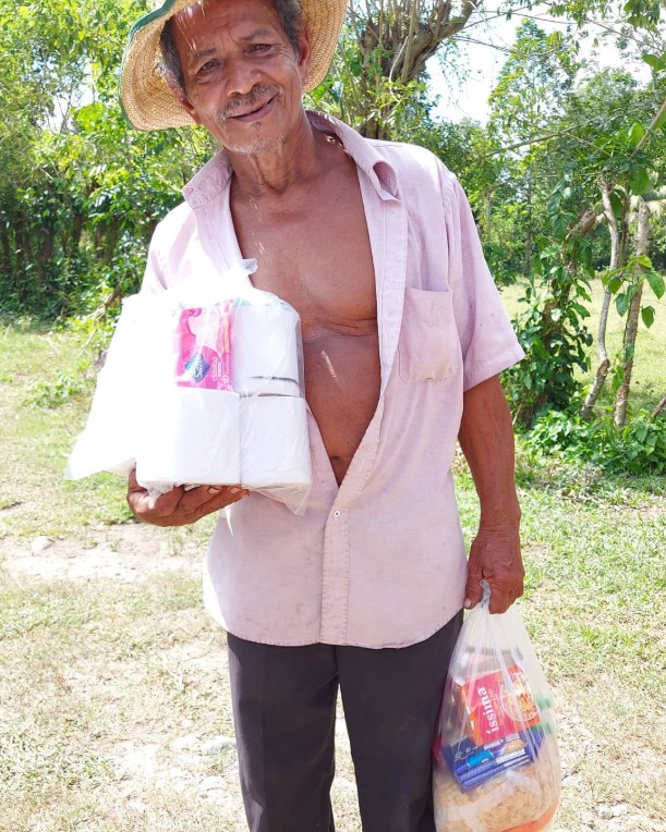 Persona recibe una bolsa con alimentos durante una entrega solidaria