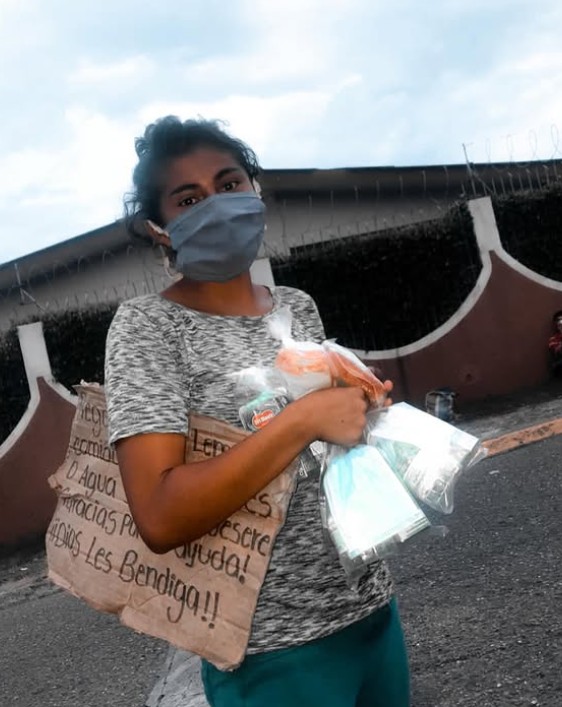 Joven muestra alimentos e insumos recibidos durante una campaña de ayuda